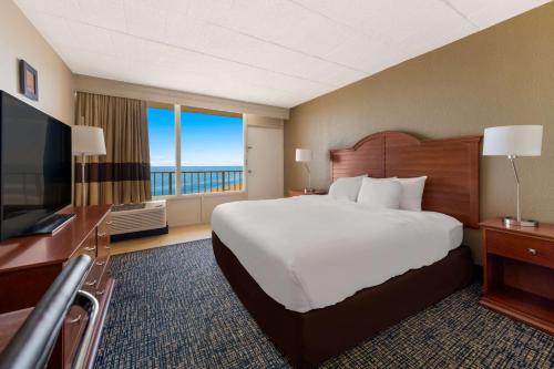 a hotel room with a large bed and a television at Comfort Inn South Oceanfront in Nags Head