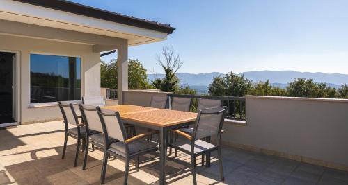 a table and chairs on the balcony of a house at Villa Vitovlje in Vitovlje
