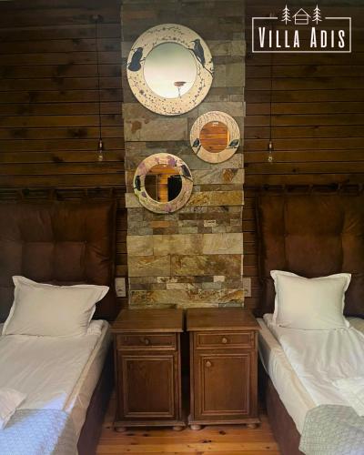a bedroom with two beds and a mirror on the wall at Villa Adis with Hot Pool & Jacuzzi by BookVillaBG in Borovets