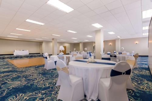 a banquet hall with white tables and white chairs at Comfort Inn South Oceanfront in Nags Head