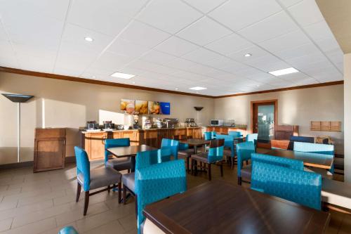 a dining room with tables and blue chairs at Comfort Inn South Oceanfront in Nags Head