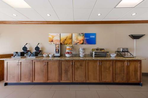 a kitchen with wooden cabinets and a counter top at Comfort Inn South Oceanfront in Nags Head