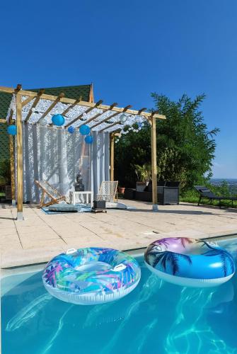 2 radeaux gonflables dans une piscine dans l'établissement Tipi en bois tout équipé avec balnéo, à Rillieux-la-Pape