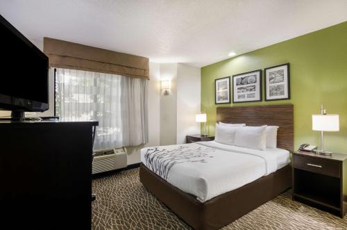 ウィンストン・セーラムにあるSleep Inn Hanes Mallのベッドと薄型テレビがあるホテルの部屋