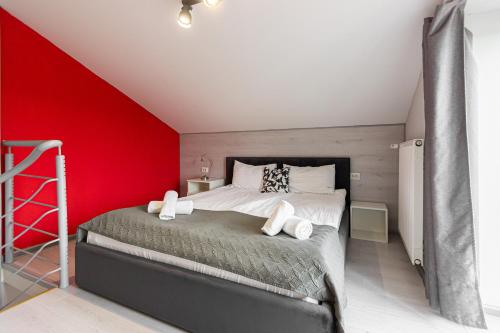a bedroom with a large bed with a red wall at Stories Hub in Lviv