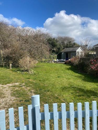 a white picket fence in front of a yard at The Bell Ringers Cottage in Loddiswell