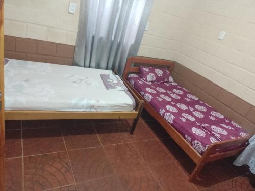 a small bed in a room next to a window at hospedaje in Garupá
