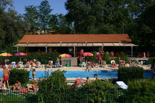 un groupe de personnes assises dans une piscine dans l'établissement Dkamping Village - International Camping Ispra, à Ispra