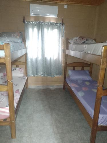 a room with three bunk beds and a window at hospedaje in Garupá