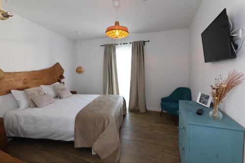a bedroom with a bed and a tv on the wall at Cangalho Village House Premium in Azueira