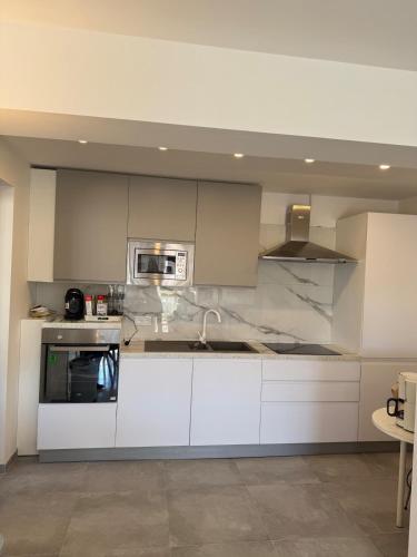 une cuisine avec des armoires blanches et un micro-ondes dans l'établissement Central location, terrace, 2 bedrooms, à Cannes