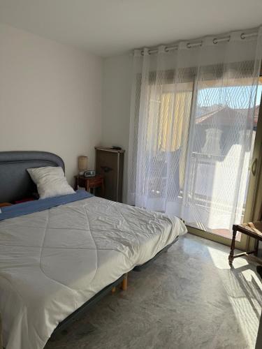 une chambre avec un lit et une grande fenêtre dans l'établissement Central location, terrace, 2 bedrooms, à Cannes