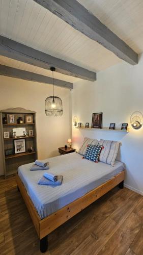 une chambre avec un grand lit dans une pièce dans l'établissement Maison de campagne à 15 minutes de Conques, à Conques-en-Rouergue