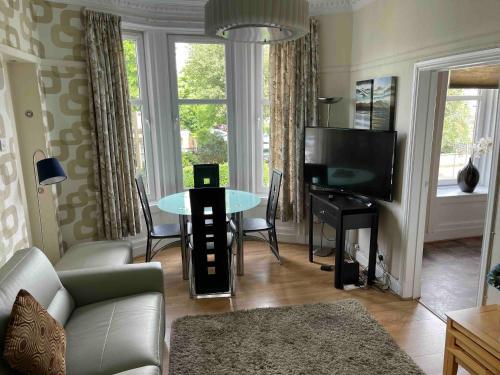 a living room with a couch and a tv and a table at Scotstoun 1 Bed Flat in Glasgow