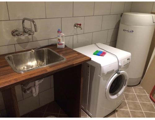 a kitchen with a sink and a washing machine at HyttaMi in Stranda
