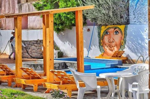 a table and chairs and a painting of a woman at Deja vu Villas Dahab in Dahab