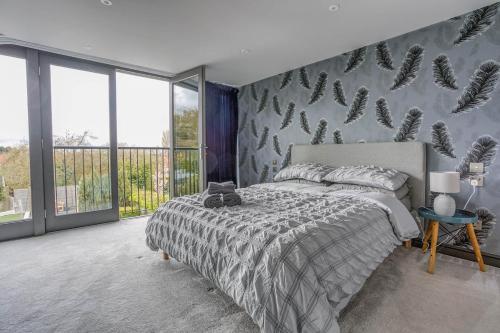 a bedroom with a bed and a wall of windows at The Retreat Luxury Coastal Villa near Sandringham Crabpot Cottages Hunstanton in Dersingham