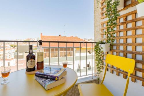 a table with bottles of wine and books on a balcony at Near Lisbon Apartment in Amadora
