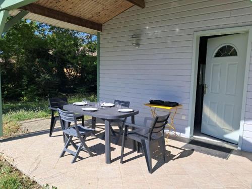 une table et des chaises assises sur une terrasse dans l'établissement La Maison des Coquilles, à Lanton