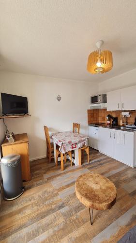 une cuisine et une salle à manger avec une table et des chaises dans l'établissement Studio cabine - centre Font-Romeu, à Font-Romeu