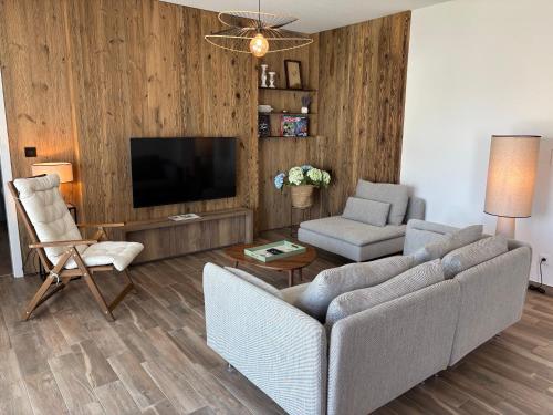 un salon avec un canapé et une télévision dans l'établissement L'Isenciel - Maison de plain pied avec Jardin et Parking, à Rouffach