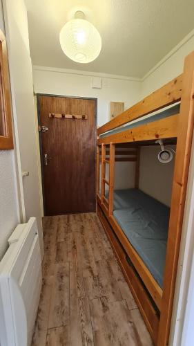 Cette chambre comprend 2 lits superposés et une porte. dans l'établissement Studio cabine - centre Font-Romeu, à Font-Romeu