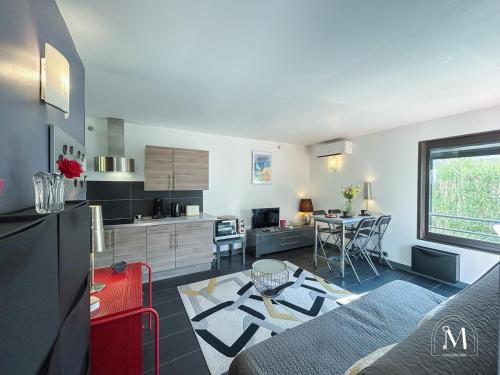 un salon avec un canapé et une cuisine dans l'établissement Rez-de-jardin à 1km du centre-ville de Six-Fours, à Six-Fours-les-Plages