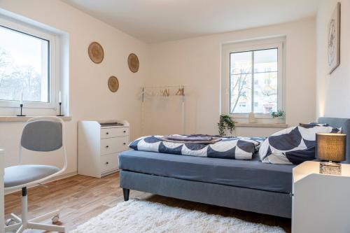 a bedroom with a bed and a desk and a chair at Atelierwohnung am Stadtpark in Chemnitz