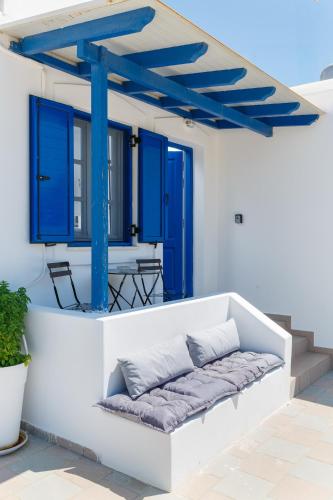 a bench on a porch with blue doors and windows at Aitheras Luxury Suites in Protorgia