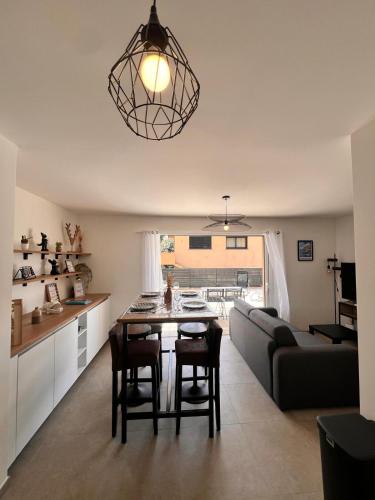 une cuisine et un salon avec une table et un canapé dans l'établissement I Sognu - Charmant Appartement Neuf Proche du Port, à Porto-Vecchio
