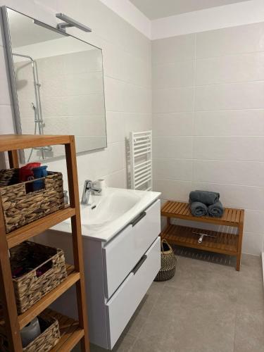 une salle de bain avec un lavabo et un miroir dans l'établissement I Sognu - Charmant Appartement Neuf Proche du Port, à Porto-Vecchio