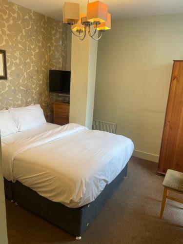 a bedroom with a bed and a tv and a chair at Hotel 1843 Reading in Reading