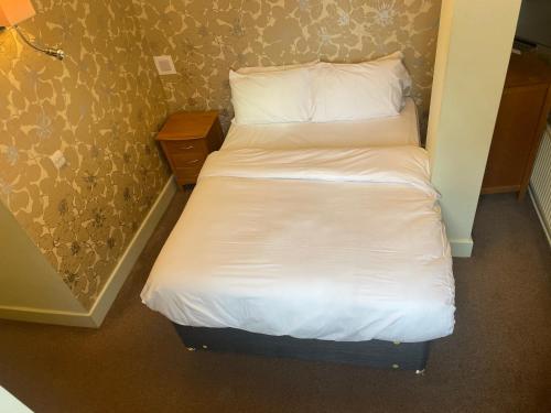 a small bed with white sheets and pillows at Hotel 1843 Reading in Reading