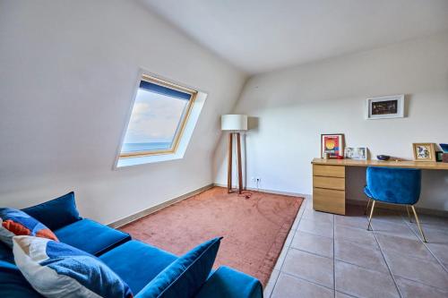 - un salon avec un canapé bleu et un bureau dans l'établissement Appartement Ornano - Welkeys, à Blonville-sur-Mer