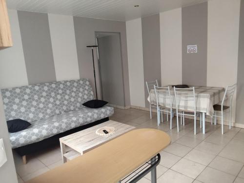 un salon avec un canapé et une table dans l'établissement Appartement avec cour fermée, à Andelot