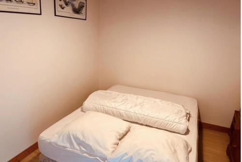 Cette petite chambre comprend un lit avec des draps blancs. dans l'établissement Gîte la Turballe France, à La Turballe