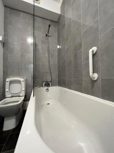 a bathroom with a white tub and a toilet at ResiLets - Brighton Road, Central, 2 Mile From NCL in Gateshead