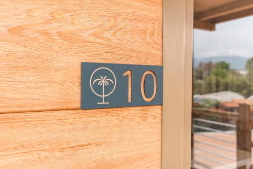 a door number with a palm tree on it at Domvs Glamp in Baveno