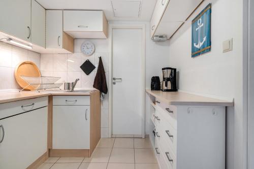 a kitchen with white cabinets and a white door at Baumfuchs Ferienbungalow in Wesenberg