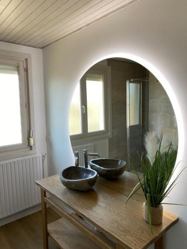 a bathroom with two sinks on a wooden table at Le Nid - Maison proche de la forêt in Frouard