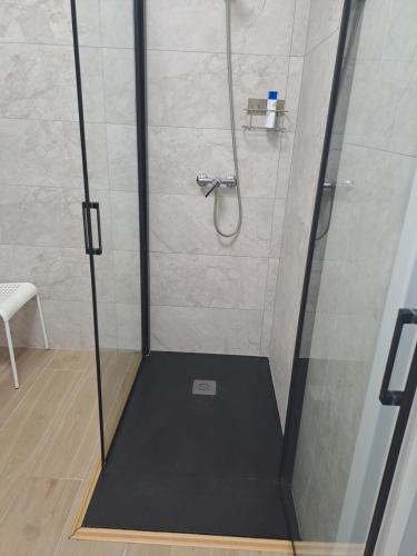 a shower with a glass door in a bathroom at Pension Diana 2 in O Pedrouzo