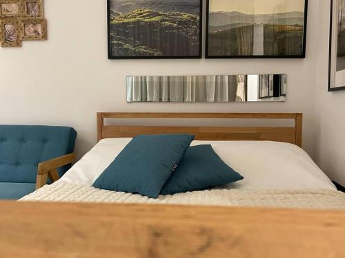 a bedroom with a bed and a blue chair at Tiny Nest - Sava Center, Belgrade in Belgrade