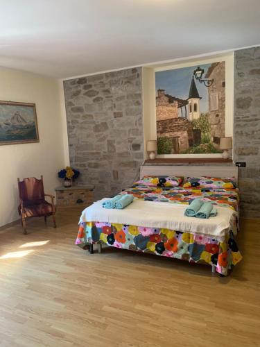 a bedroom with a bed with a painting on the wall at Ca di Viet in San Giorio