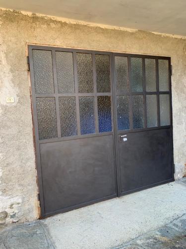 a metal garage door with glass windows on a building at Ca di Viet in San Giorio