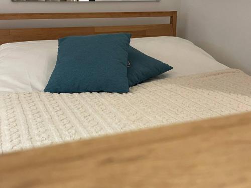 a bed with a blue pillow on top of it at Tiny Nest - Sava Center, Belgrade in Belgrade