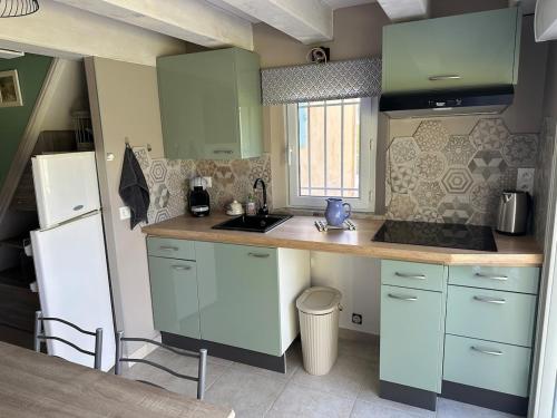 une cuisine avec des placards verts et un comptoir dans l'établissement Charming outbuilding with pool in Peypind'Aigues, à Peypin-dʼAigues