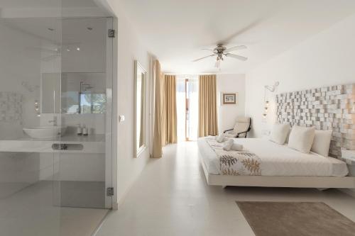 a white bedroom with a bed and a bathroom at Charming Villa Óbidos by LovelyStay in Casal do Narcizo
