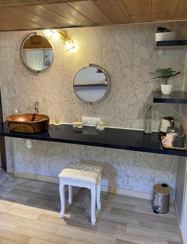 La salle de bains est pourvue d'une baignoire, d'un lavabo et d'un tabouret. dans l'établissement Péniche Le Pescalune - Chambre d'hôtes, à Arles