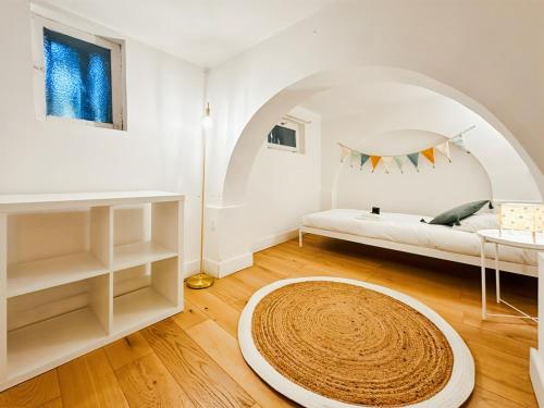 a white living room with a bed and a large rug at Magnifique Appartement 8 personnes hyper centre in Montpellier