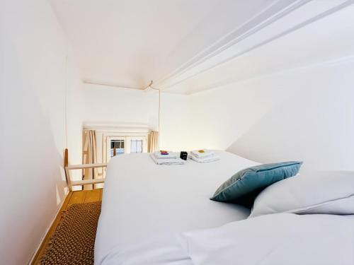 two beds in a room with white walls at Magnifique Appartement 8 personnes hyper centre in Montpellier